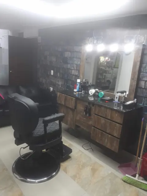 Puesto de barbería con silla y espejo iluminado